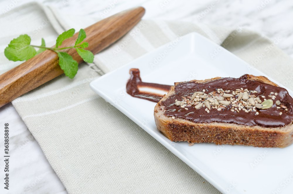 Nocilla toast with dried fruit. Wooden spoon background.